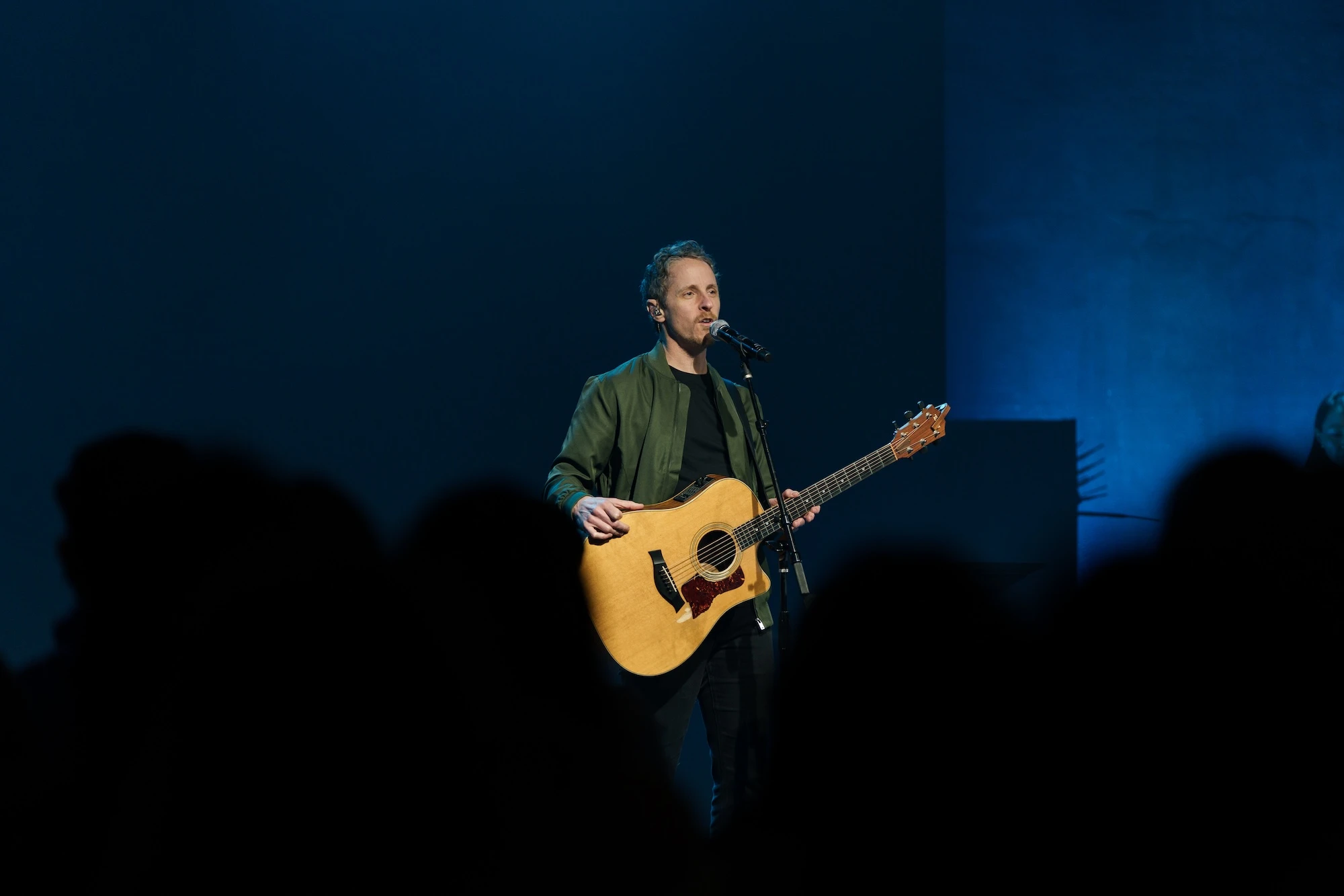 Nathan Armstrong performing on stage with acoustic guitar